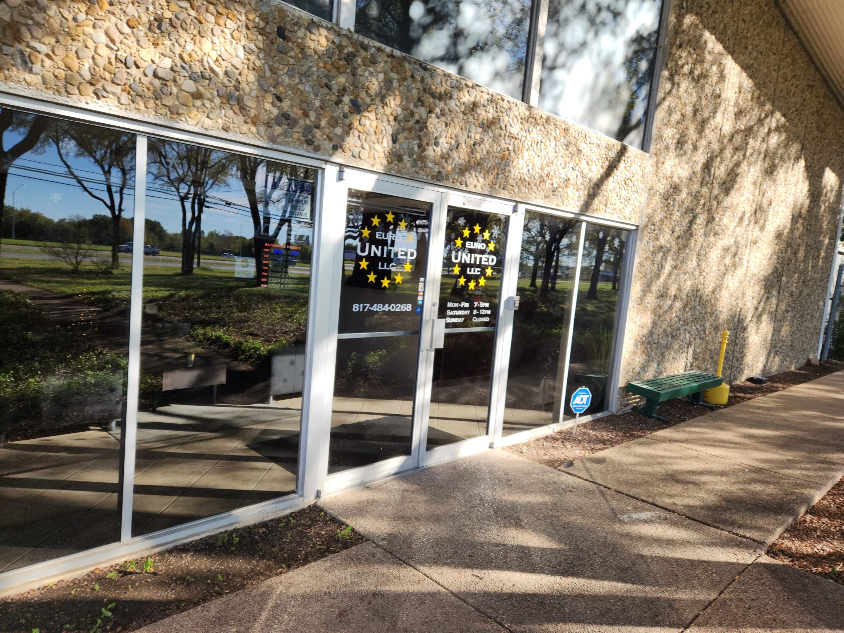 A building with two glass doors and a sidewalk.