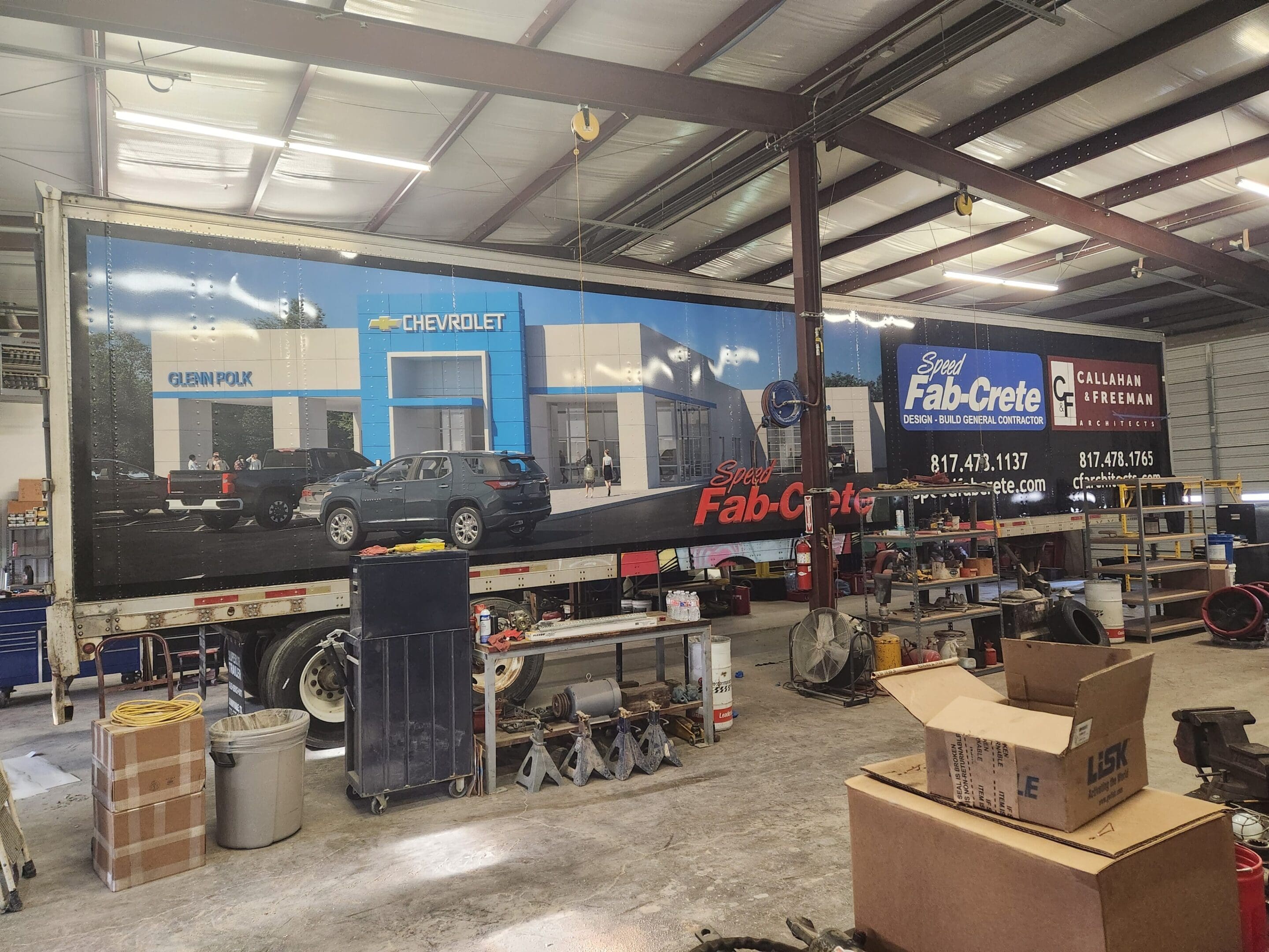 A large truck is parked in the middle of a warehouse.