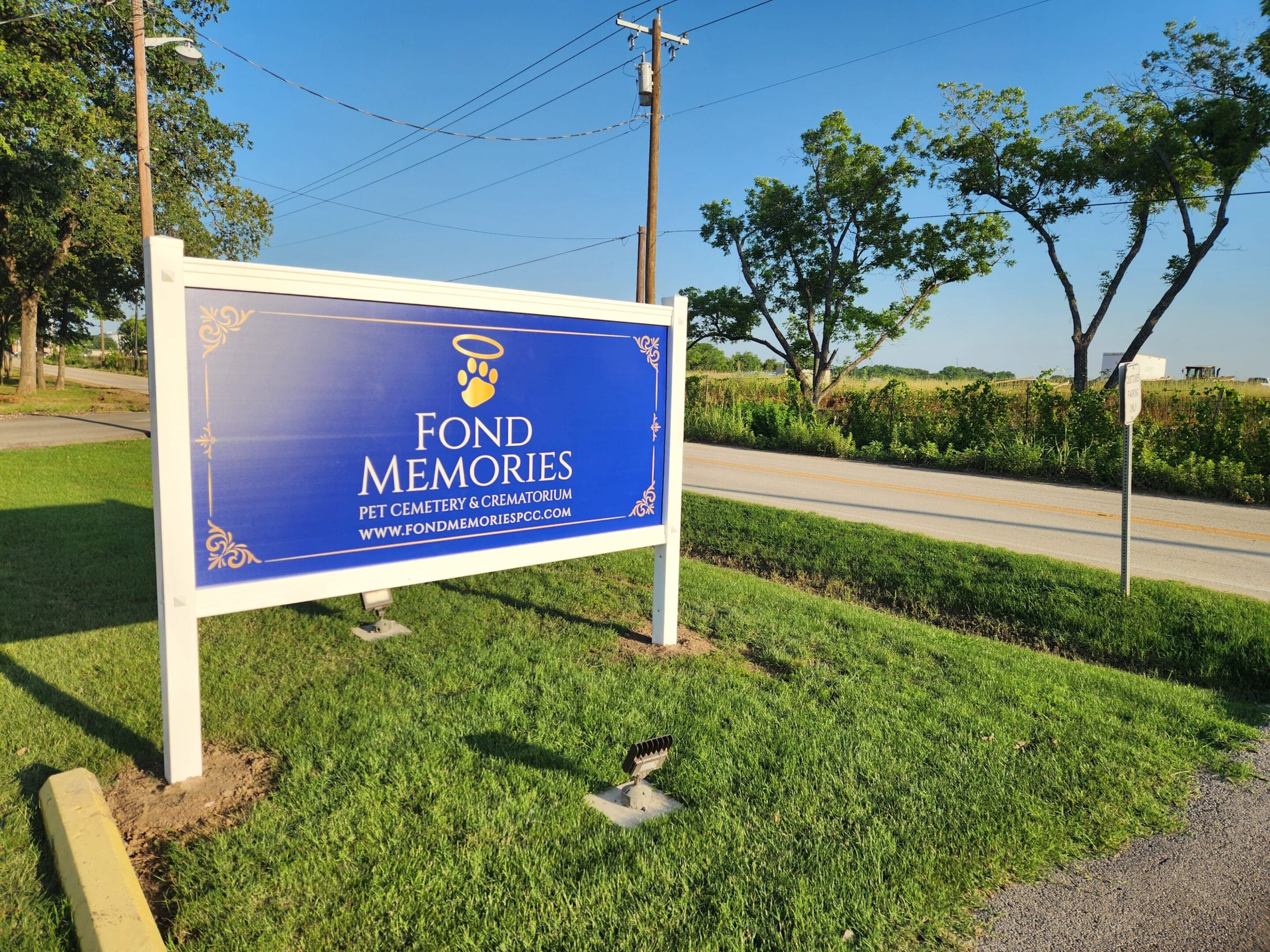 A sign that says fond memories in front of some grass.