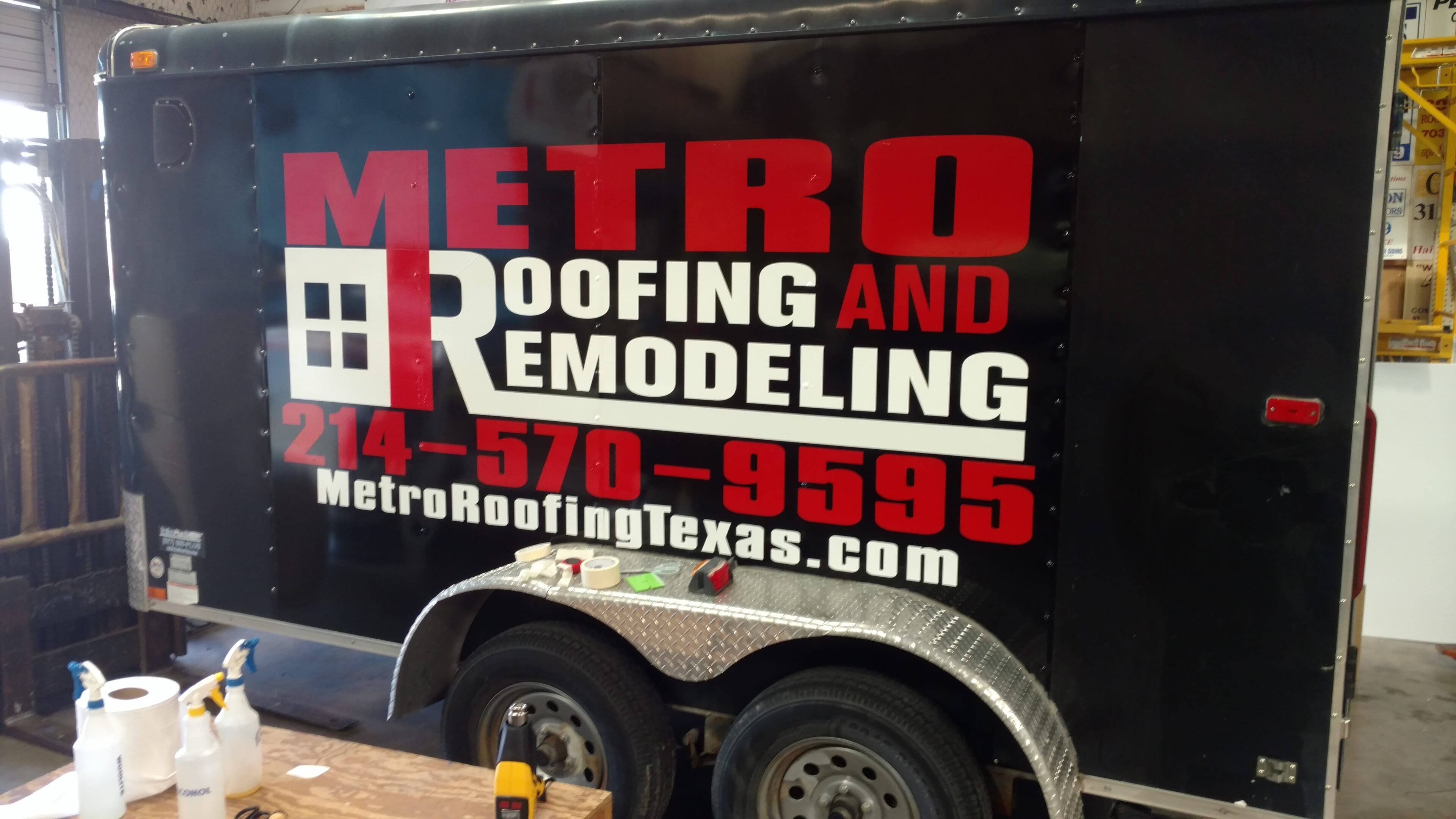 A metro roofing and remodeling trailer with the company logo on it.