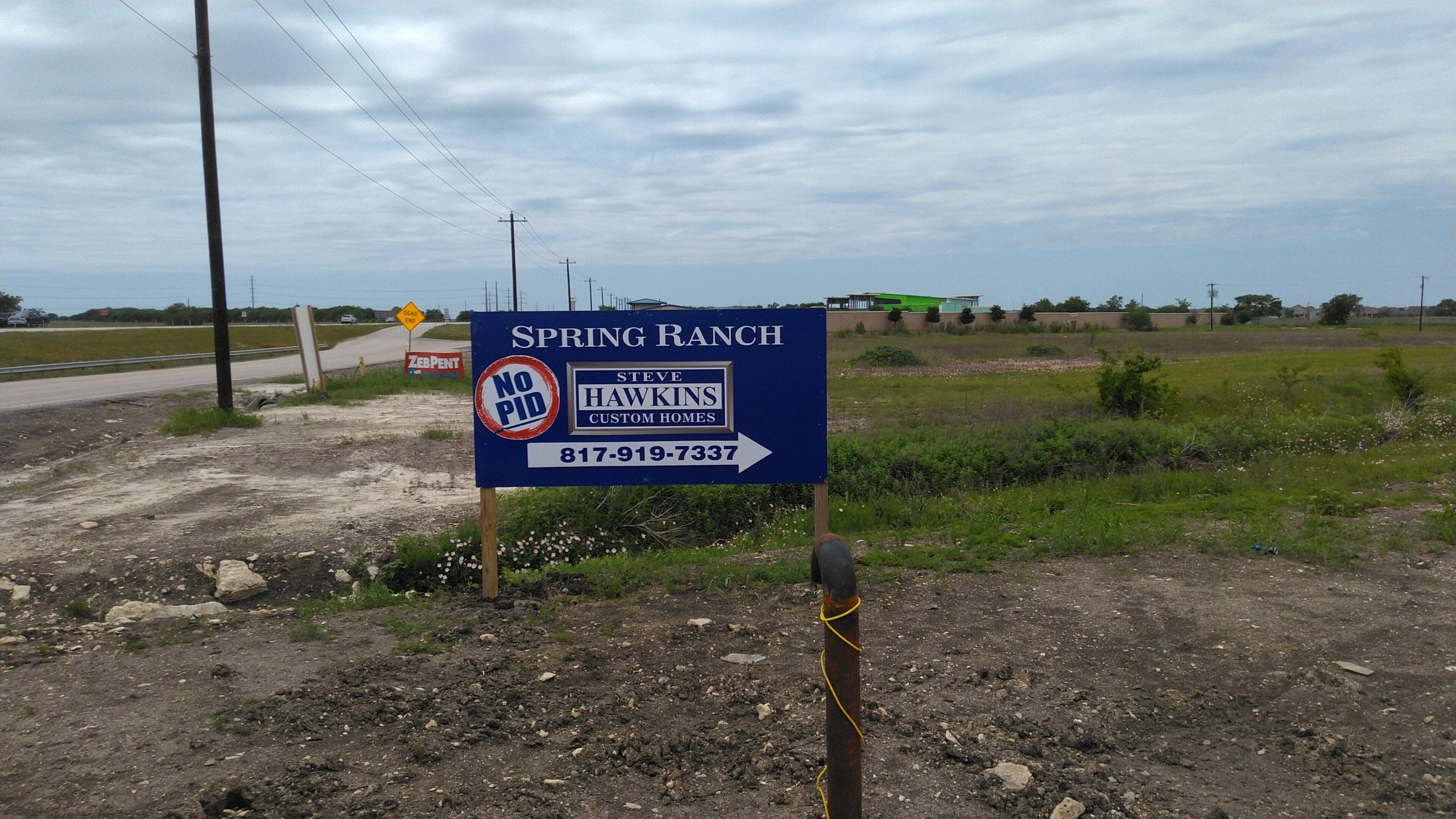 A sign in the middle of an empty field.