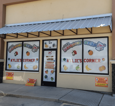 A store front with many different signs on the windows.